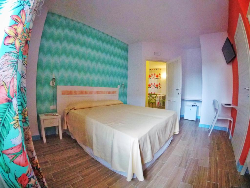 - une chambre avec un lit et un mur vert dans l'établissement Aramoni B&B, à Zambrone