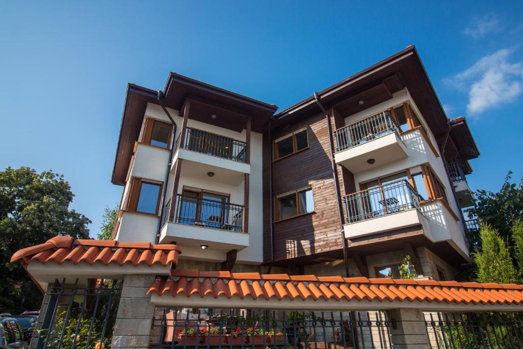 een appartementencomplex met balkons en een blauwe lucht bij Breeze Guest House in Chernomorets