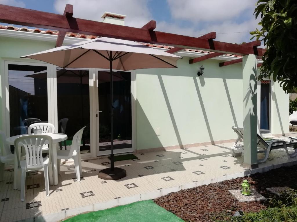 a patio with an umbrella and a table and chairs at Villa Gonçalo in Caldas da Rainha