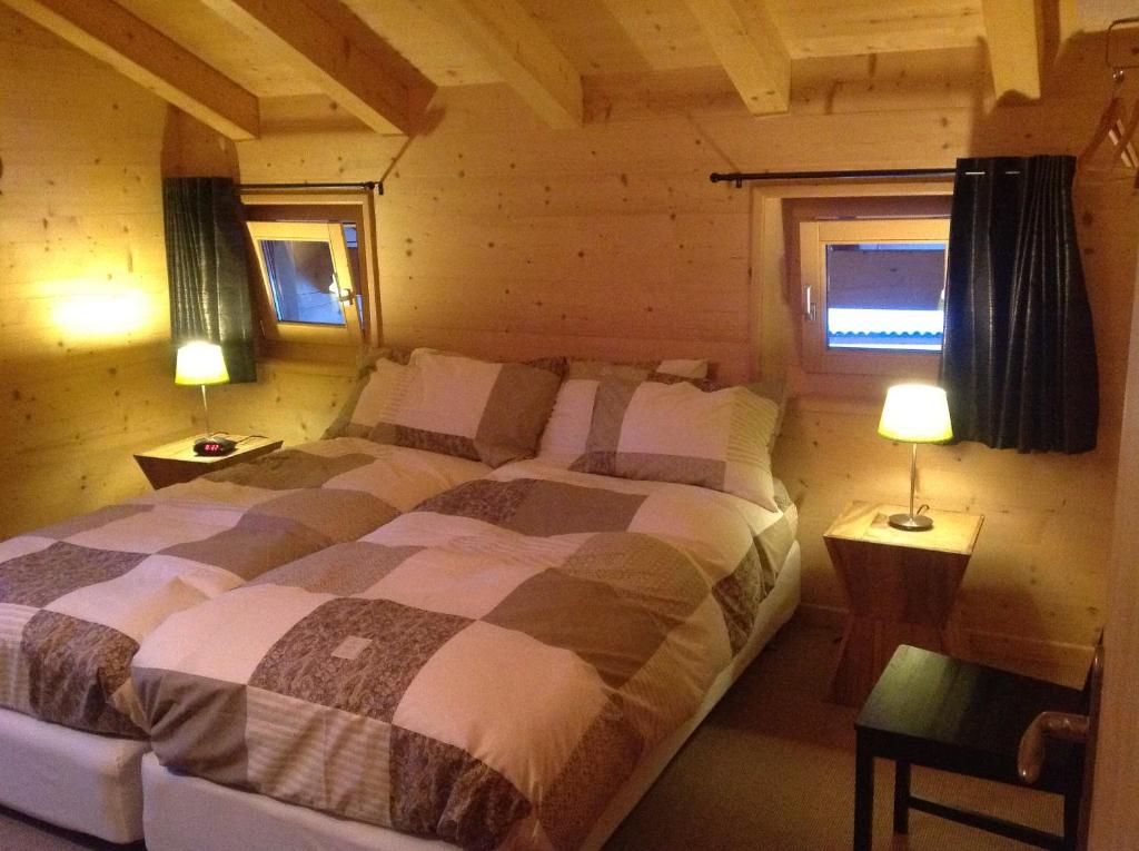 ein Schlafzimmer mit einem Bett in einem Blockhaus in der Unterkunft Chalet Courage in Champéry
