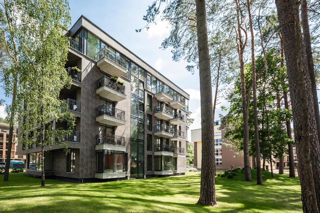 an apartment building in a park with trees at FoRest Apartments in Druskininkai