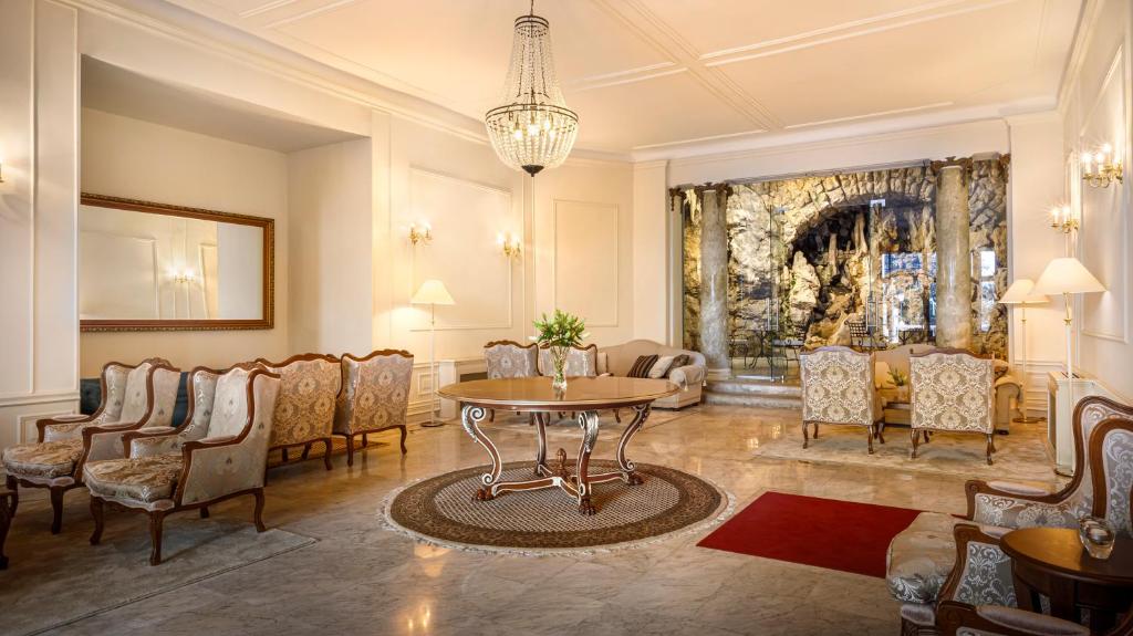 a living room with a table and chairs at Hotel Bellevue - Liburnia in Opatija