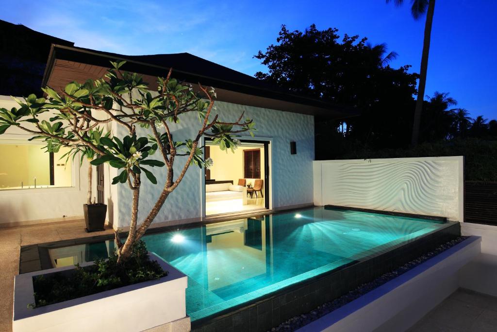 a swimming pool with a tree in a backyard at The Racha in Ko Racha Yai 