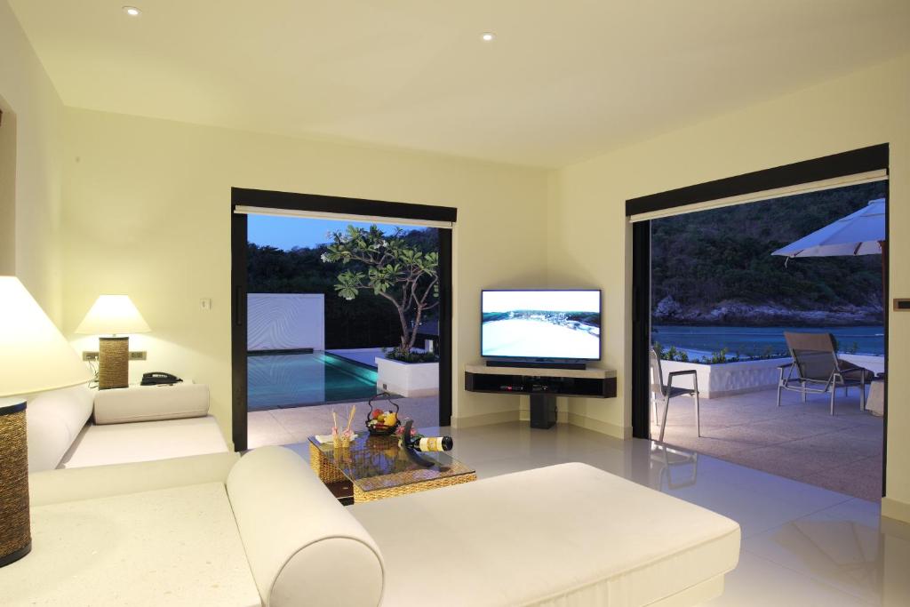 a living room with a white couch and a television at The Racha in Ko Racha Yai 