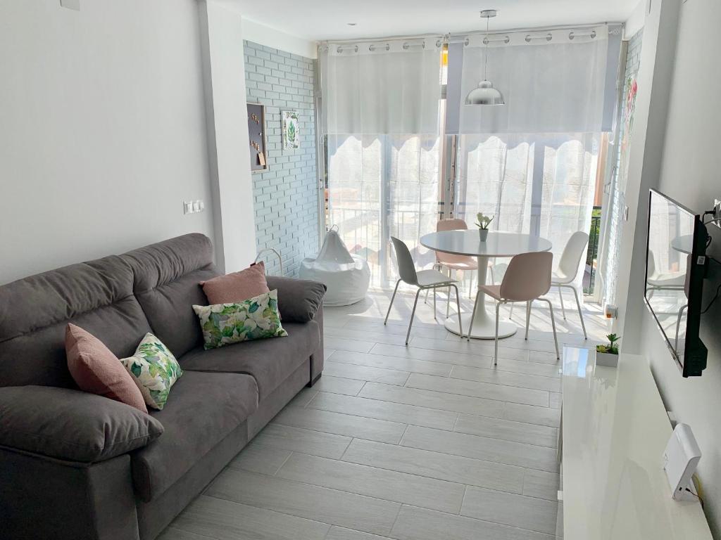 uma sala de estar com um sofá e uma mesa em Apartamento Dreamplace em Finestrat