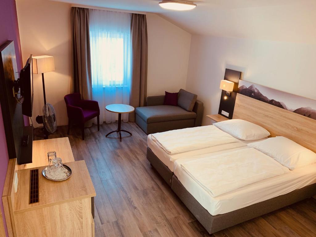 1 dormitorio con cama, sofá y mesa en Pension Lindenhof, en Grasbrunn