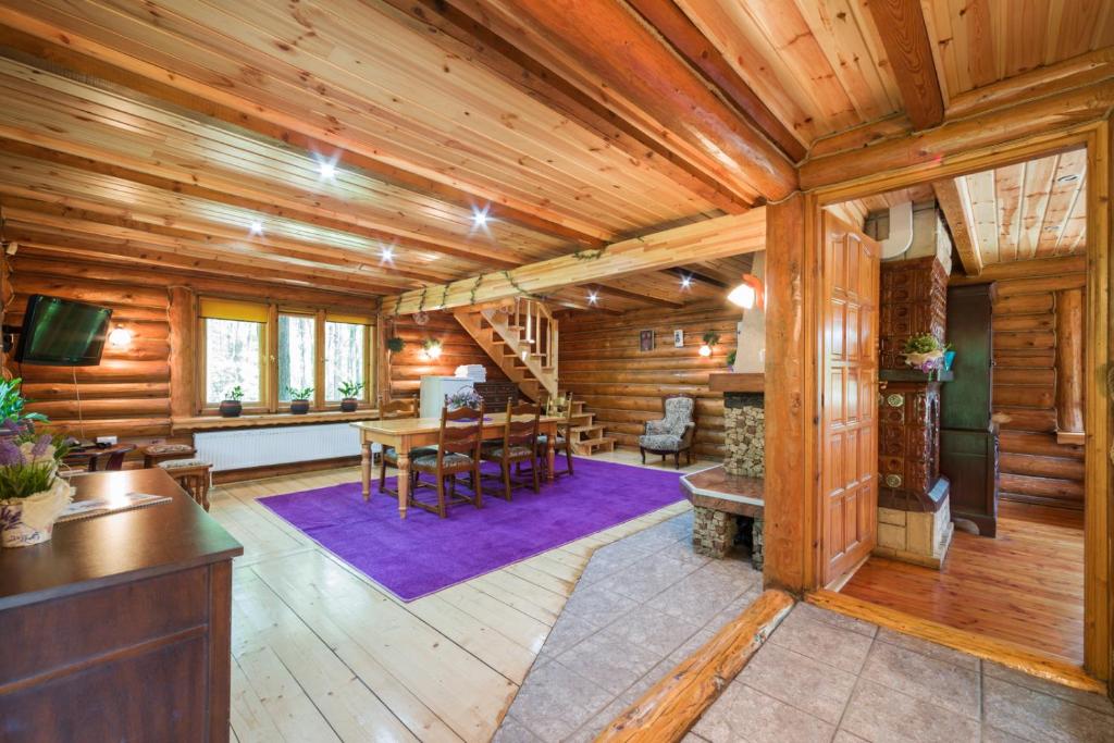 a living room with wooden walls and a wooden ceiling at Klimatyczne Domki - Całoroczne in Radomsko