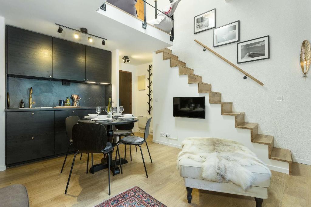 een woonkamer met een tafel en een trap bij Apartment Midi Loft in Chamonix-Mont-Blanc