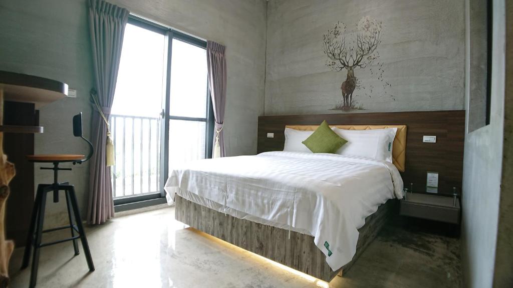 a bedroom with a bed and a large window at Tree House 民宿證號2316 民宿證號2350 in Hualien City