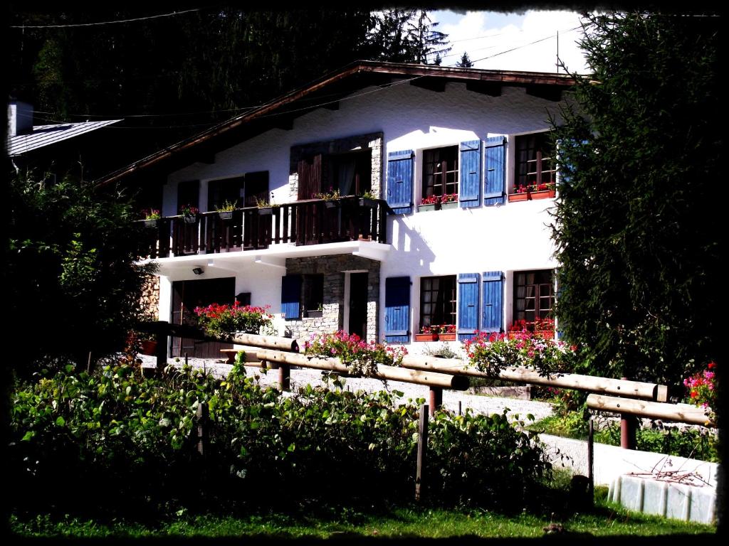 a white house with blue doors and a fence at Chamonix Lodge in Chamonix-Mont-Blanc