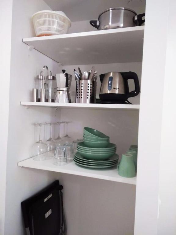a kitchen shelf with dishes and utensils on it at STUDIO VIEIL ANTIBES Marché Provençal in Antibes