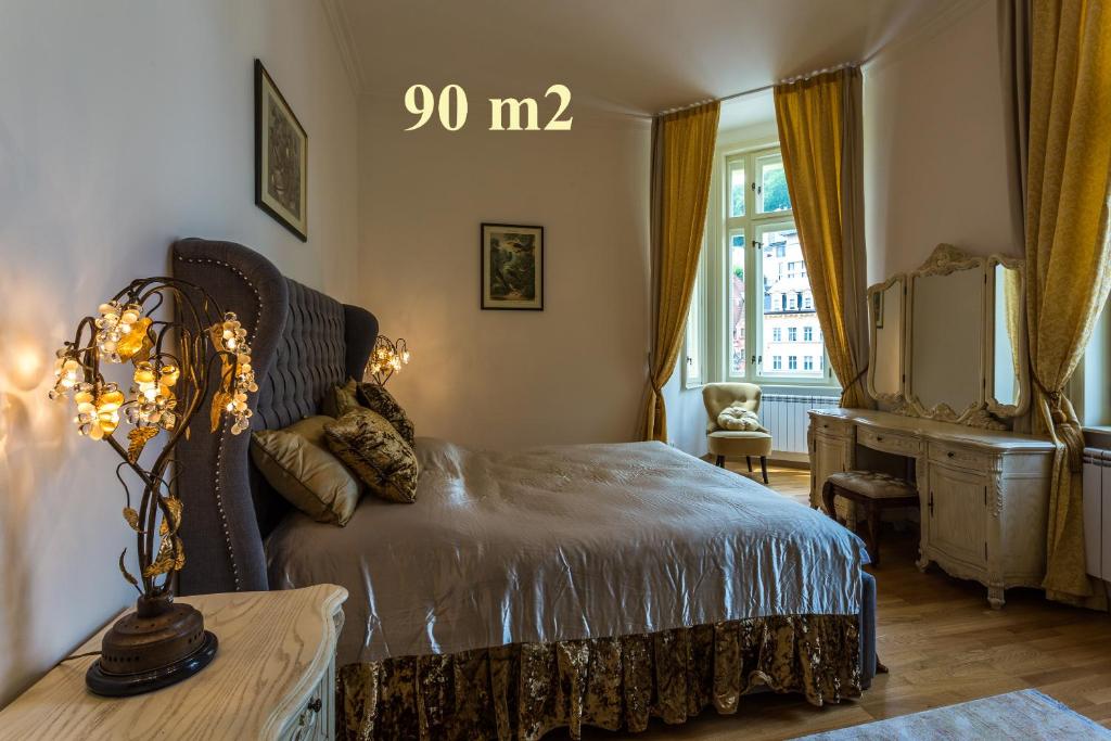 a bedroom with a bed and a desk and a window at Karlsbad Prestige in Karlovy Vary