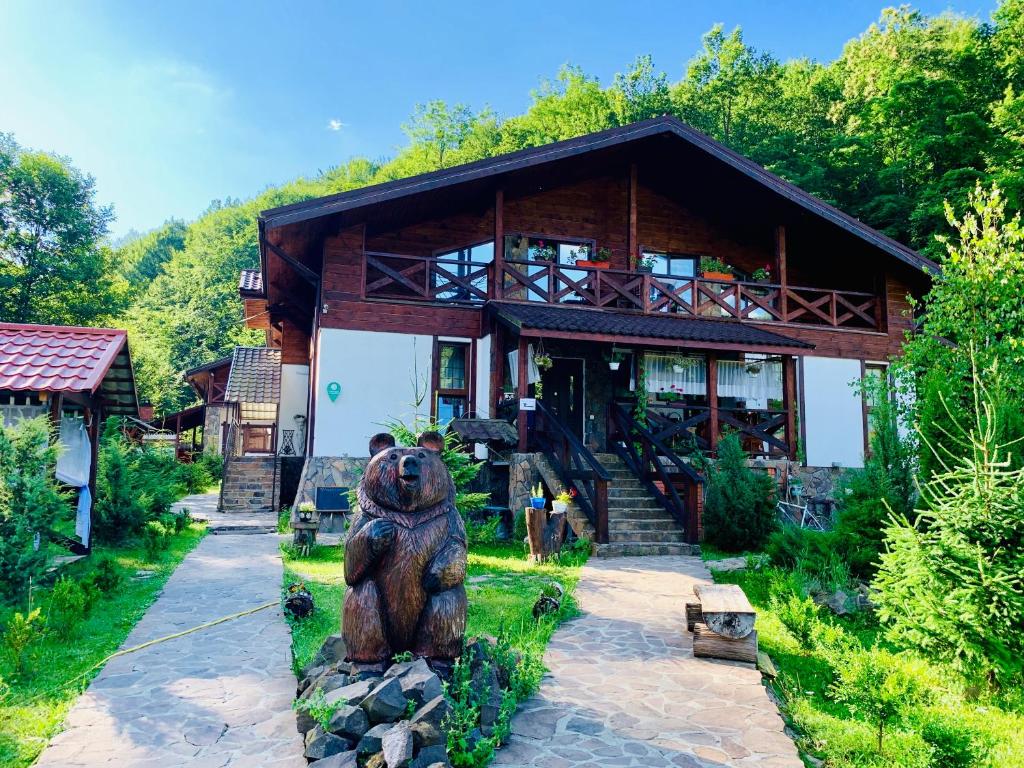 une grande statue d'ours devant une maison dans l'établissement Chalet Vedmezhe, à Polyana