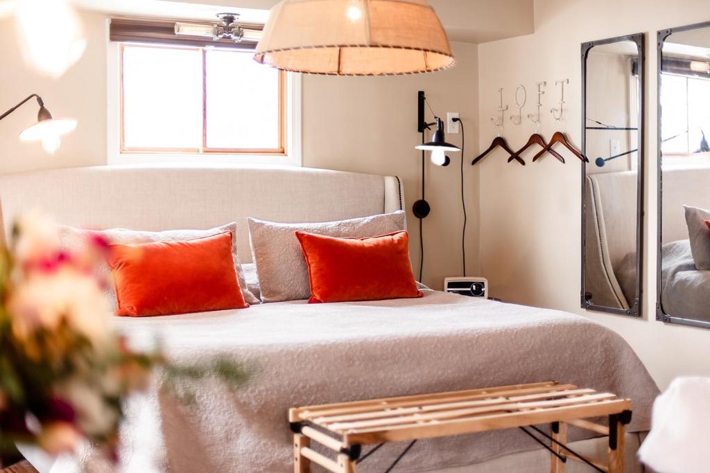 a bedroom with a bed with orange pillows and a table at The Loft in Granville