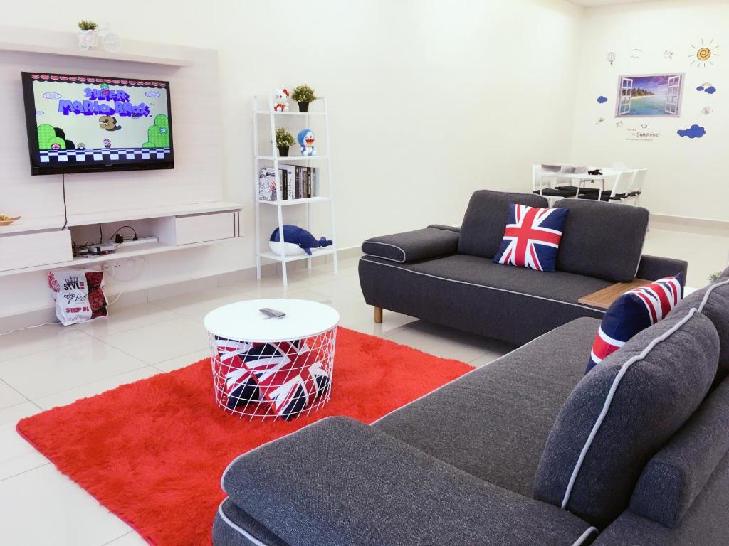 a living room with two couches and a tv at Batu Pahat Leisure Stay in Batu Pahat