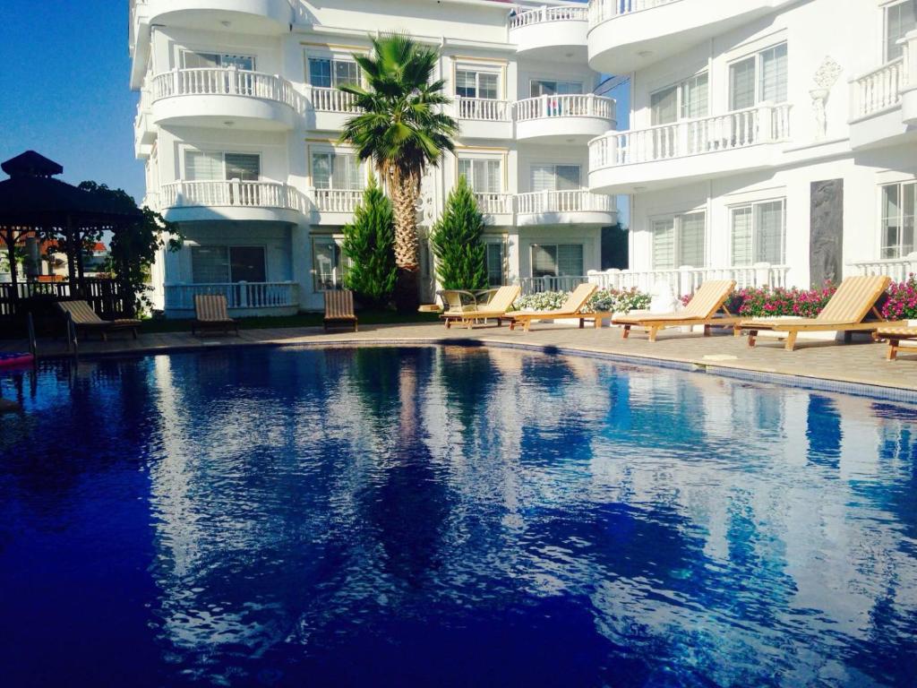 a swimming pool in front of a large building at BELKA GOLF RESİDENCE Luxury Apt Poolside Belek in Belek