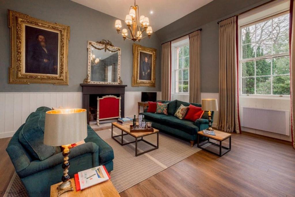 a living room with two couches and a fireplace at The Maitland at Thirlestane Castle in Lauder