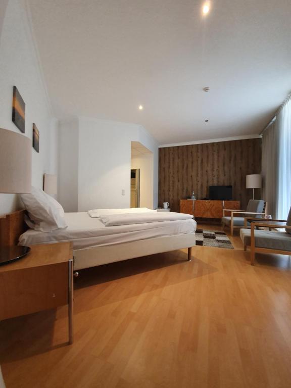 1 dormitorio grande con 1 cama grande y sala de estar en Erlanger Hof en Berlín