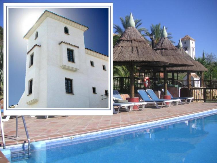 a picture of a building next to a swimming pool at Castle Tower apartment in rural holiday park 'Picasso' in Tolox