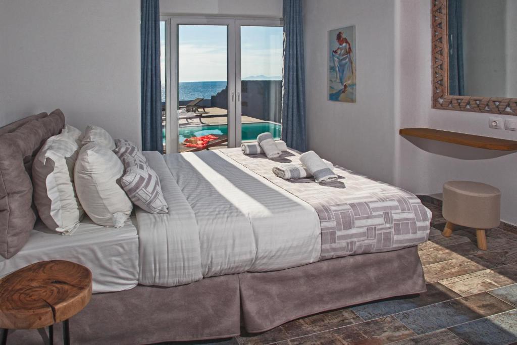 sypialnia z dużym łóżkiem i widokiem na ocean w obiekcie Abelomilos Exclusive Villa w Imerovíglion