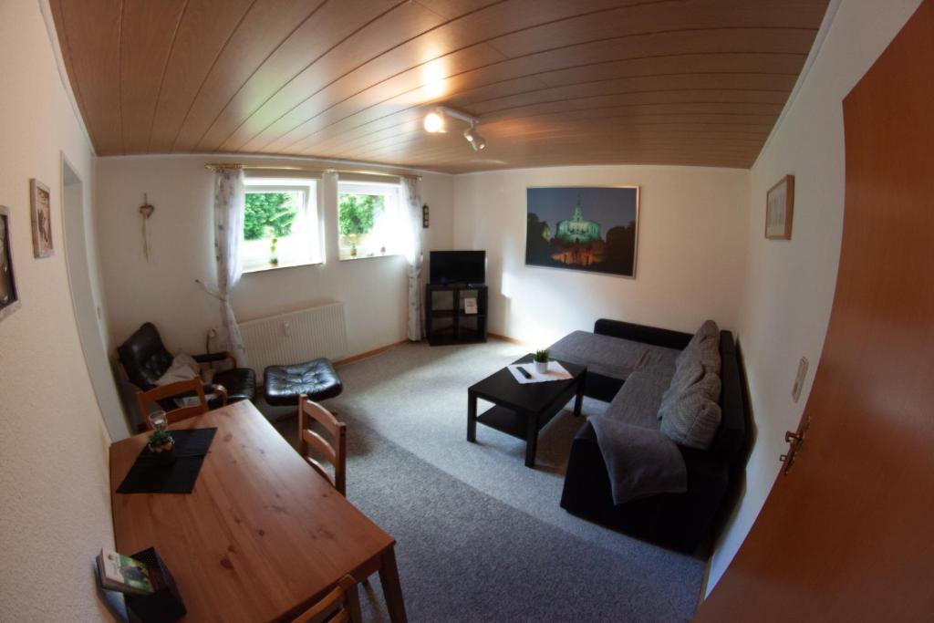 ein Wohnzimmer mit einem Sofa und einem Tisch in der Unterkunft Ruhige und gemütliche Ferienwohnung in Calden in Calden