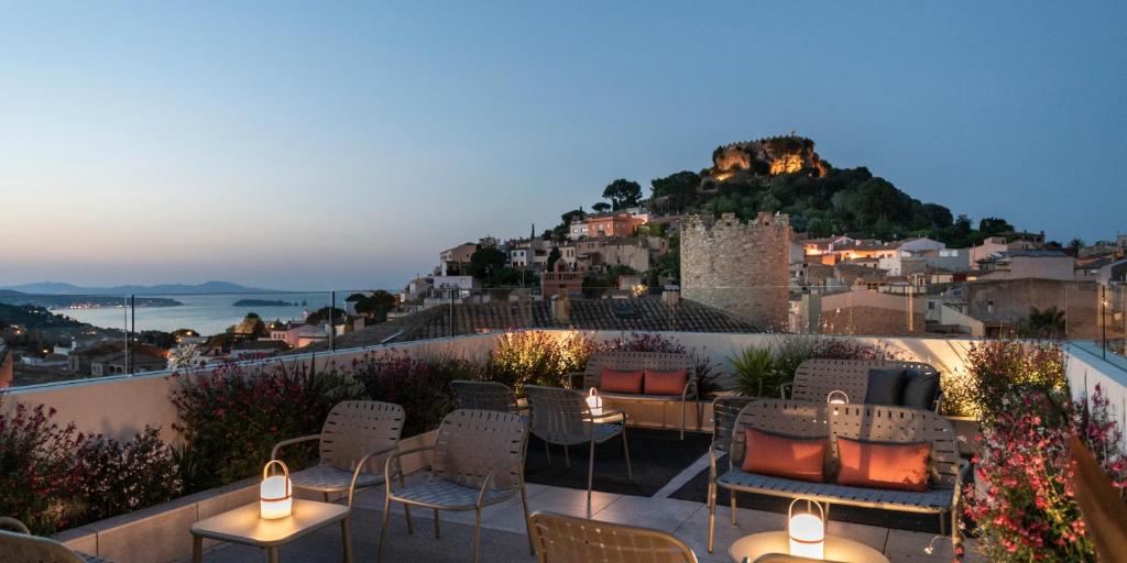 a rooftop patio with chairs and tables and a castle at Alta House Begur in Begur
