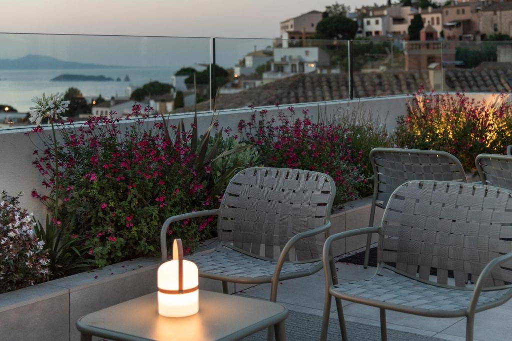 two chairs and a candle on a table on a balcony at Alta House Begur in Begur