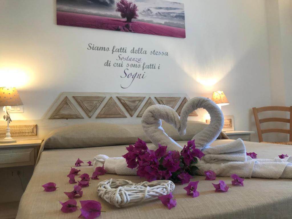 a bedroom with two towels and flowers on a bed at Monti di Jogliu in Arzachena