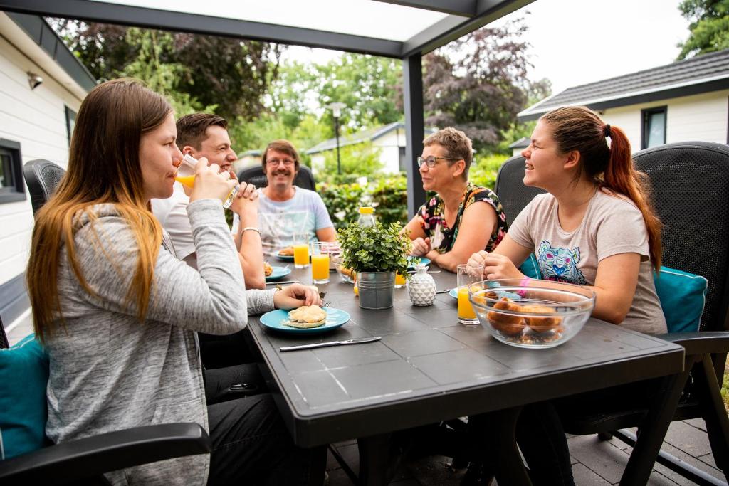 een groep mensen die aan een tafel eten bij TopParken – Recreatiepark ’t Gelloo in Ede