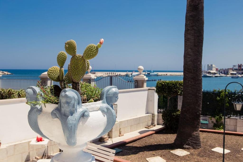 巴里的住宿－Villa Anna，一个大的白色花瓶,上面有仙人掌,靠近大海