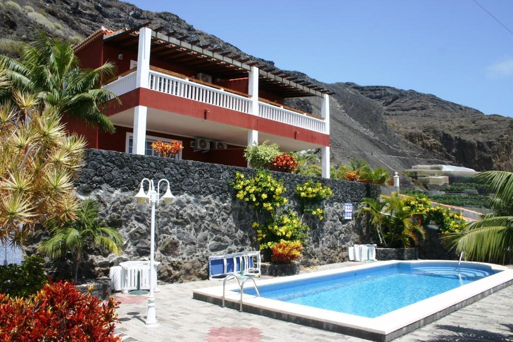 een villa met een zwembad en een huis bij Complejo Solymar in Puerto Naos