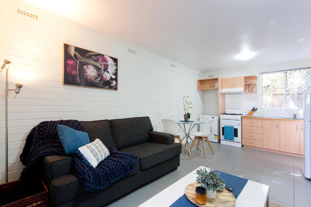 a living room with a couch and a kitchen at Hensman 5 - 1BRM Unit with Courtyard & Parking in Perth