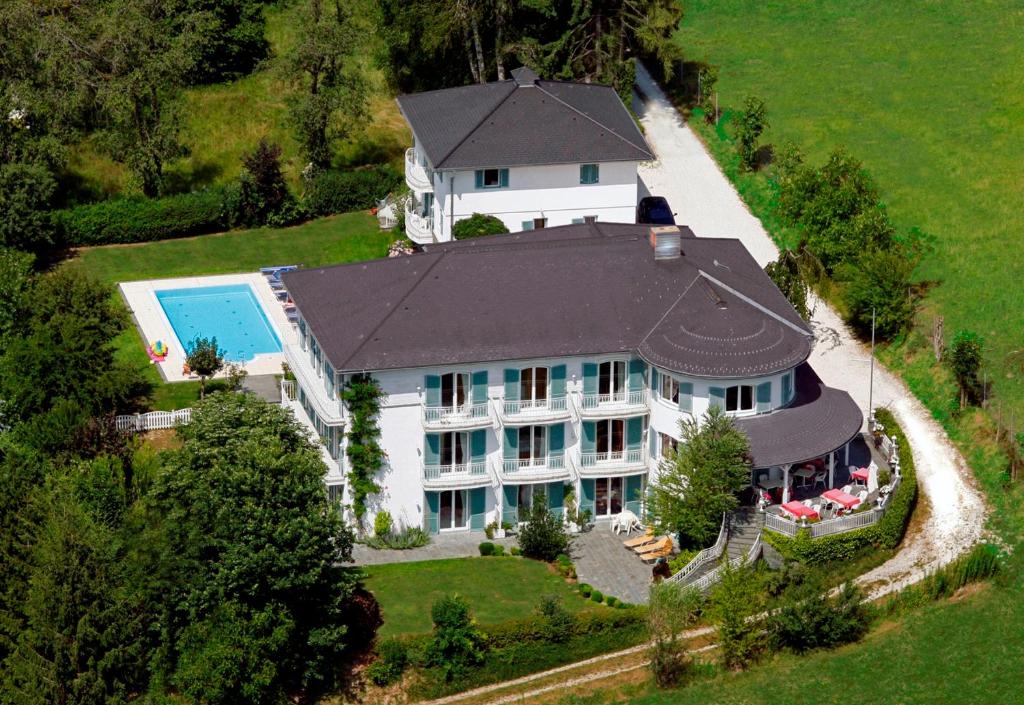 an overhead view of a large white house with a pool at Das Landhaus Hauptmann in Pörtschach am Wörthersee