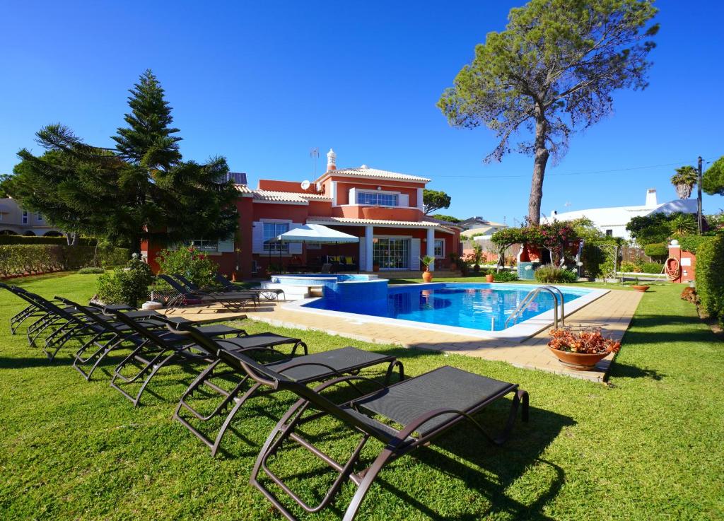 a group of lawn chairs in front of a house at Vila Luz in Vilamoura