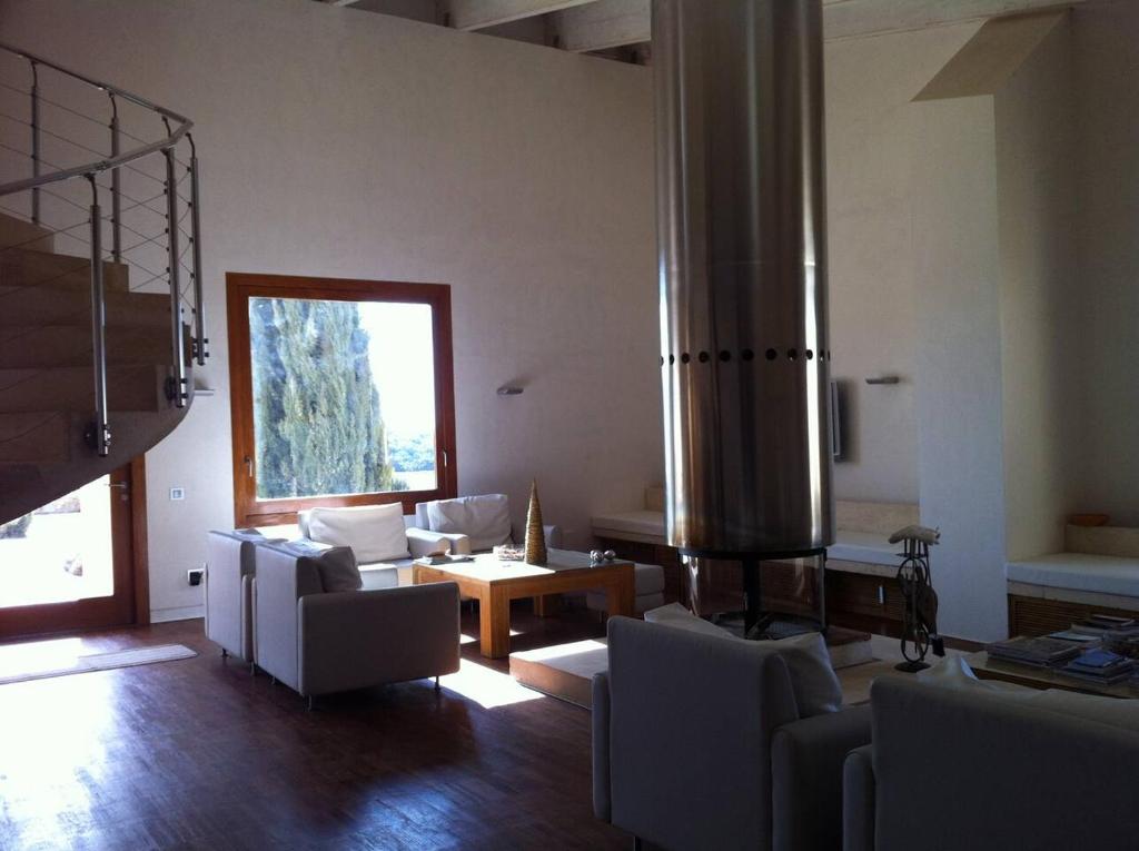 un soggiorno con mobili bianchi e una grande finestra di Casa Herreros - Alojamiento Rural con Pista de Padel a Rada de Haro