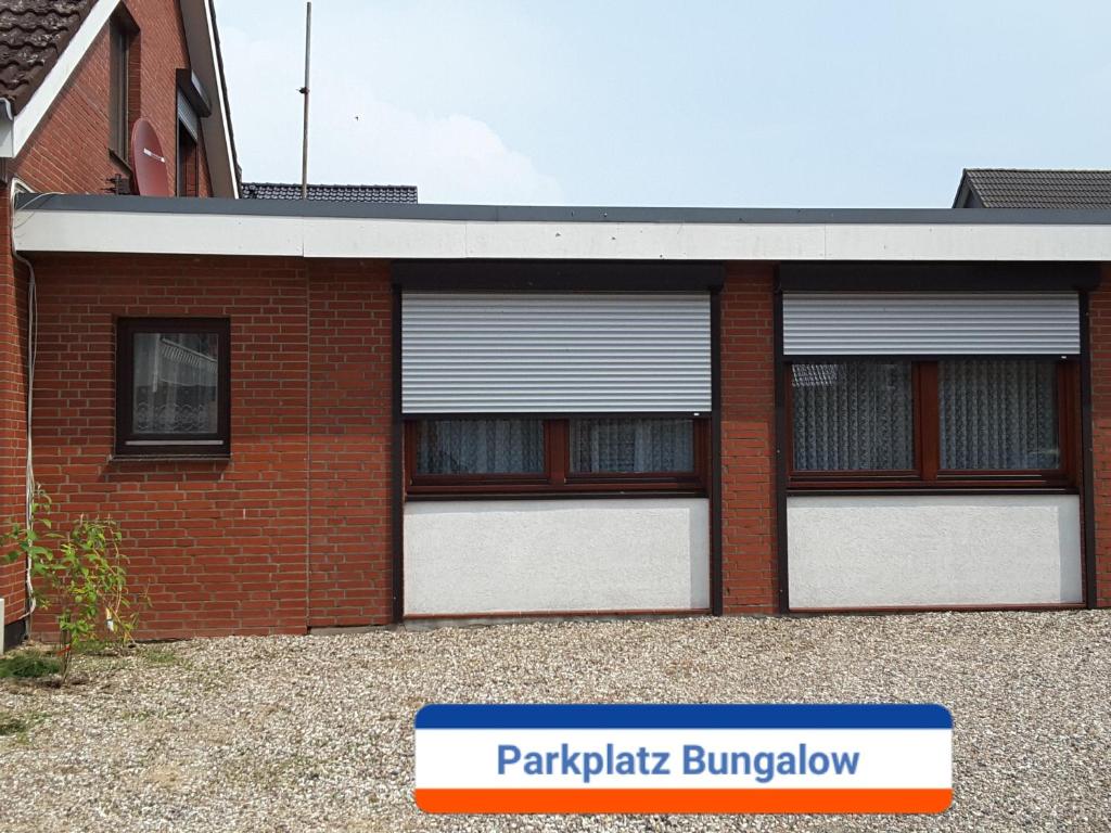 a red brick building with two white garage doors at Haus Hopp - Bungalow in Dahme