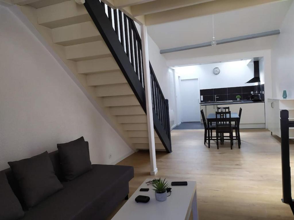 sala de estar con sofá y escalera en Duplex plein centre ville 10B, en Malestroit