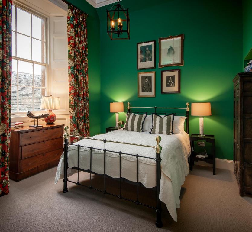 sypialnia z zielonymi ścianami, łóżkiem i oknem w obiekcie The Earl & Countess at Thirlestane Castle w mieście Lauder