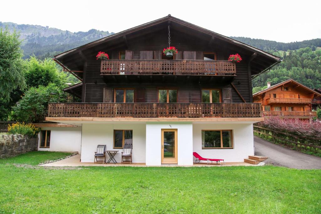 a large wooden house with a balcony on top at Chalet le Knou in Champéry