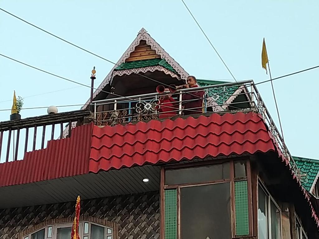 un uomo sul balcone di una casa di Vamoose Kanchan Kanya a Sukhia Pokhari