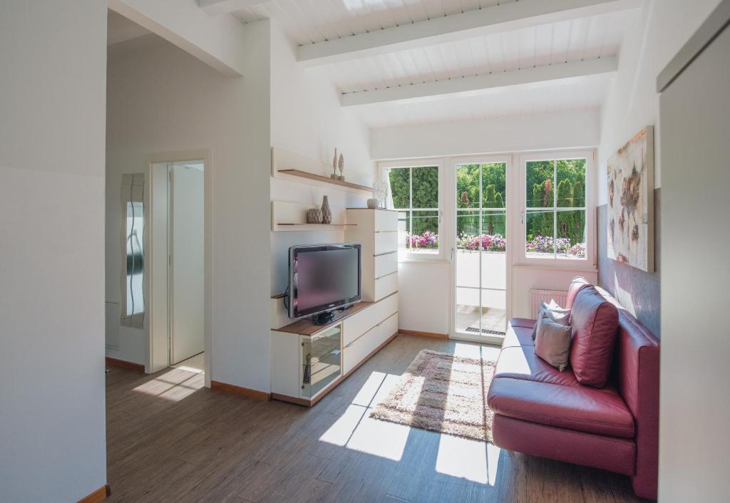 salon z czerwoną kanapą i telewizorem w obiekcie Gartenhof w mieście Bressanone
