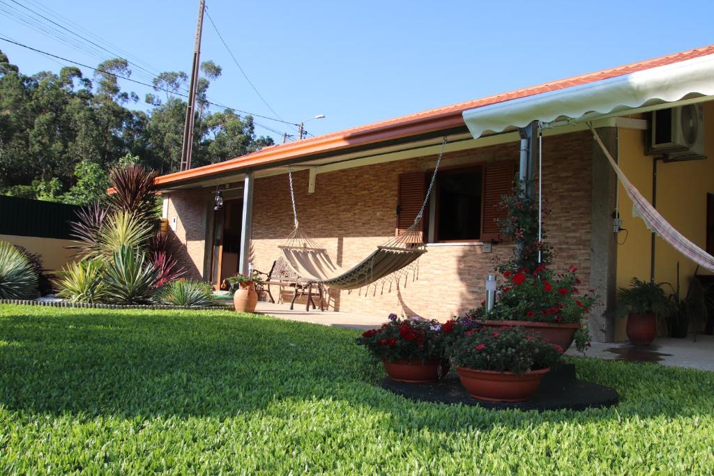 une maison avec un hamac dans la cour dans l'établissement Casa flor da laranjeira, à Ponte de Lima