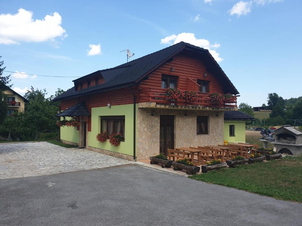 a small building with a balcony on the side of it at Plitvice Rooms in Smoljanac