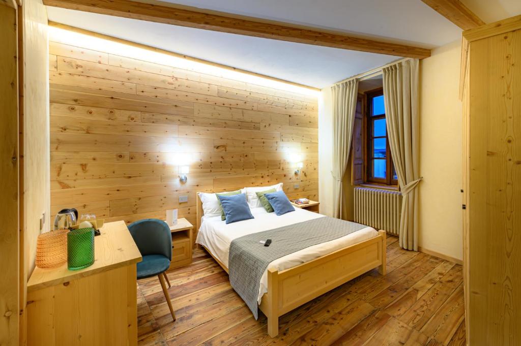 a bedroom with a bed and a wooden wall at B&B Antica Residenza Centro Storico in Tirano