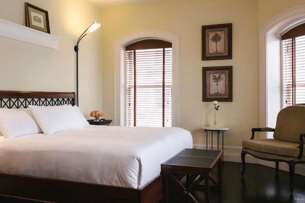 1 dormitorio con 1 cama blanca grande y 1 silla en Hotel Place D'Armes, en Montreal