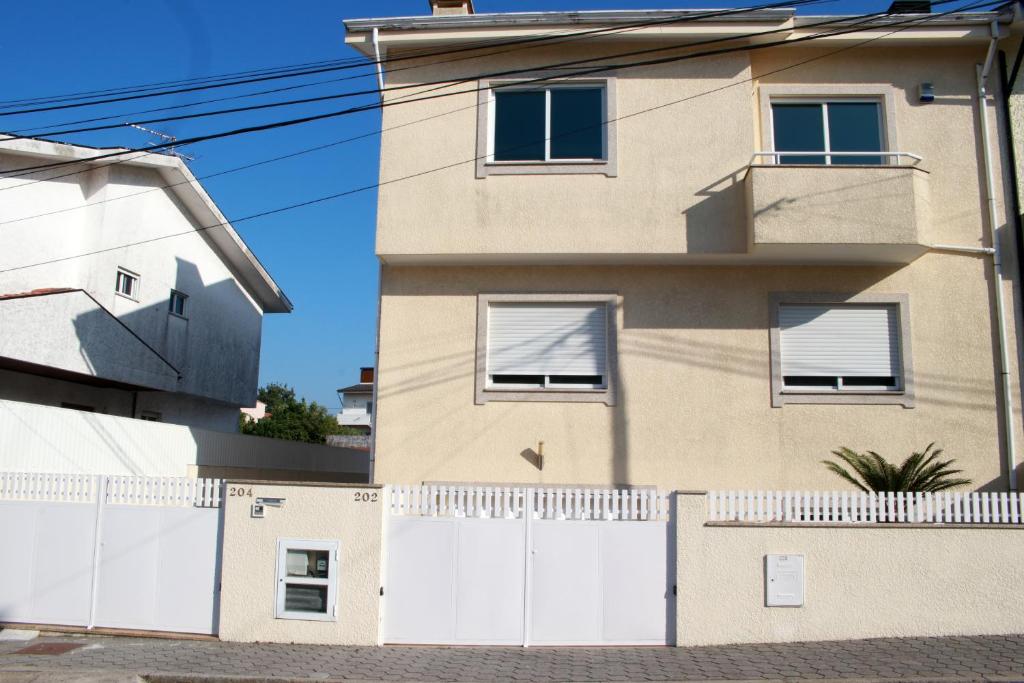 una casa con una cerca blanca delante de ella en Porto Cruz, en Vila Nova de Gaia