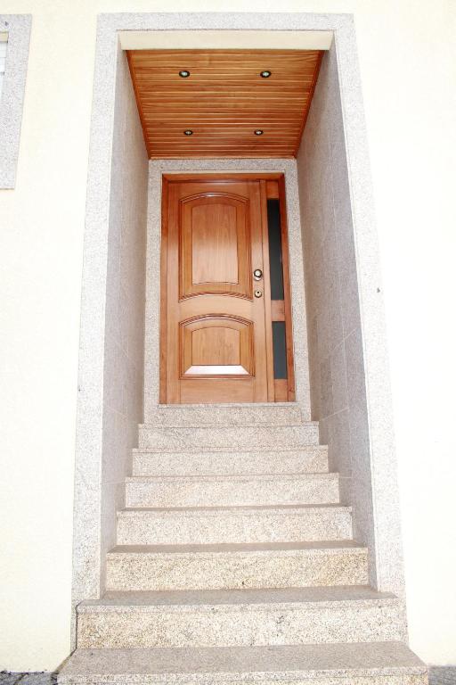a wooden door on a white building with stairs at Porto Cruz House in Vila Nova de Gaia