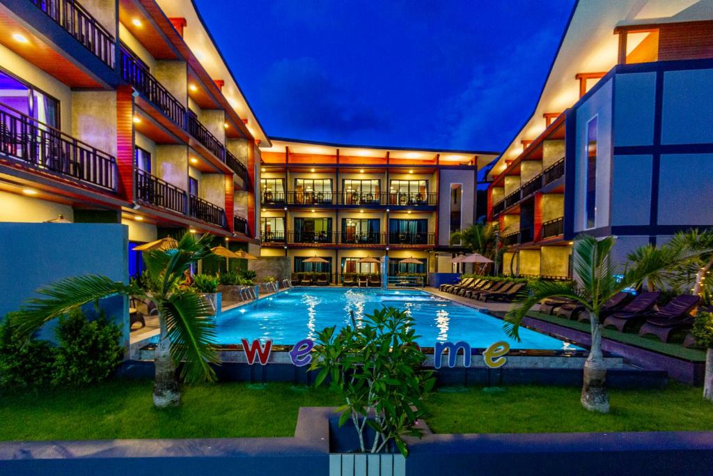 a large hotel with a swimming pool at night at Coco Bella Hotel in Phi Phi Islands