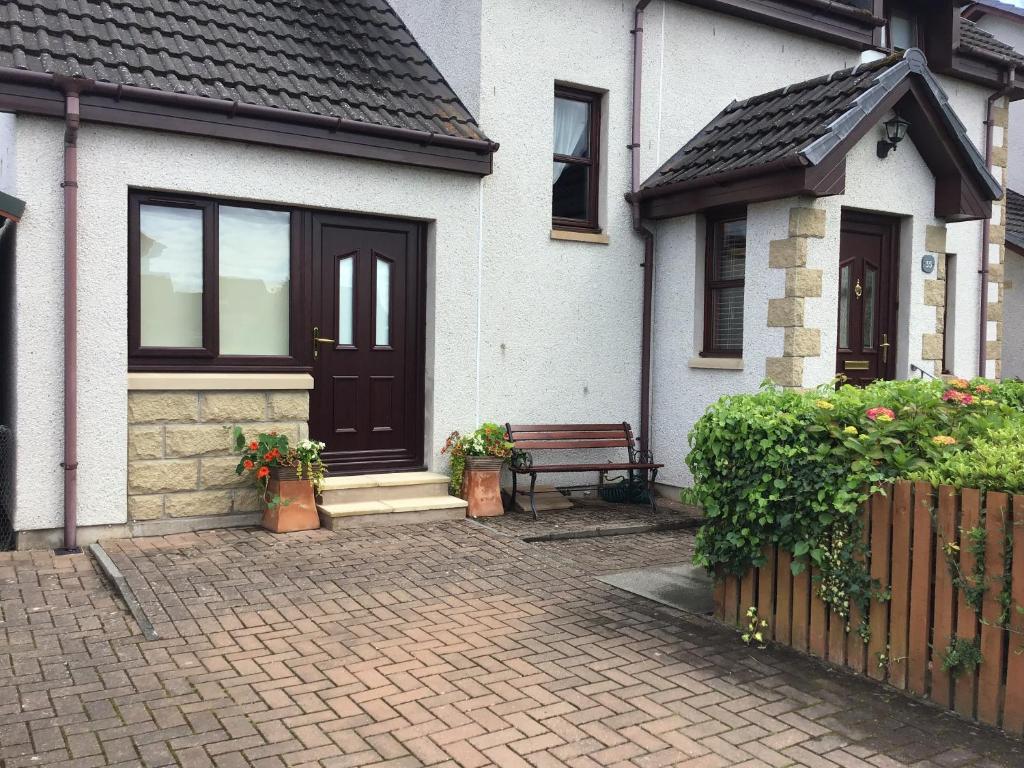 a house with a bench in front of it at Exclusive Private double room, en-suite wet room Private entrance in Forres