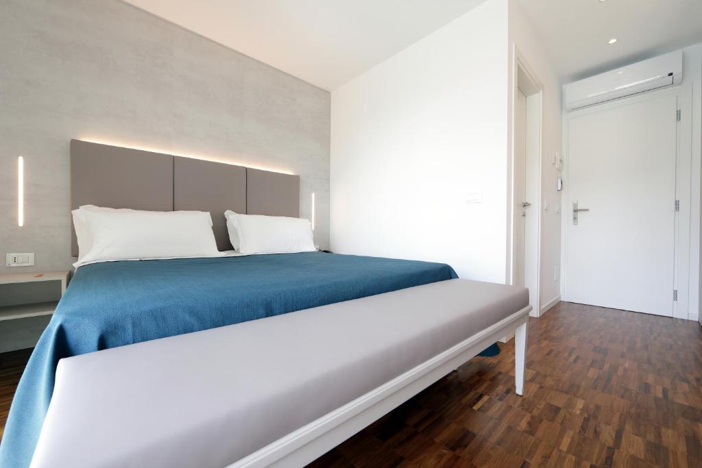 um quarto com uma cama grande e um cobertor azul em Hotel Simi Lan em Lignano Sabbiadoro
